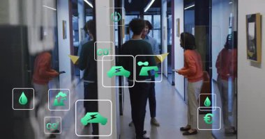 Tabletle ekolojik ölçümleri vurgulayan simgeler onlara katılırken, takım sarı klasörü değiş tokuş ediyor. Sürdürülebilirlik, takım çalışması, yenilik, modern, işbirliği, dijital, çevre dostu