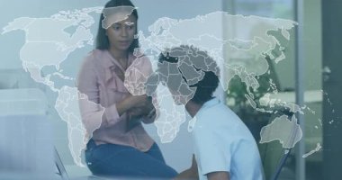 Kadın tablet tıklayarak dünya haritasını çıkarırken, VR çalışanı da iş veri tablolarına bakıyor. İşbirliği, takım çalışması, veri görselleştirme, dijital teknoloji, profesyonel çevre, yenilik, modern ofis