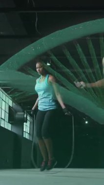 İp atlayan kadın ve erkeğin üzerinde dönen DNA 'nın canlandırması. Dijital arayüz küresel spor ve performans konsepti dijital olarak oluşturulmuş video.