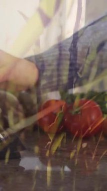 Kafkas kadının sebze doğraması ve mutfakta tablet kullanması. Yaşam tarzı, yemek pişirme ve beslenme konsepti dijital olarak oluşturulmuş video.