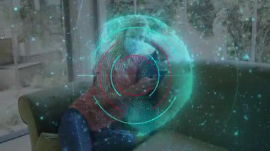 Kanepede oturan kadın tablet tutuyor, UI 'yi maddeleşerek dönen bir küre oluşturuyor, sağlığı takip ediyor. Gelecekçi, teknoloji, refah, sağlık, yenilik, modern, dijital