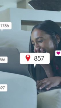 Dizüstü bilgisayar kullanan kadın üzerinde simge ve veri işleme animasyonları. Dijital olarak oluşturulmuş küresel sosyal medya, bağlantılar, hesaplama ve veri işleme kavramı.