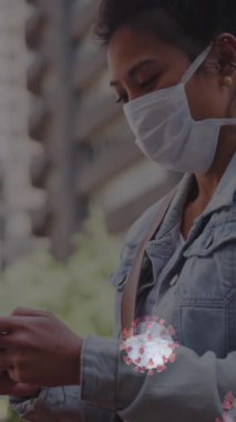 Makro Coronavirus hücrelerinin şehir caddesinde akıllı telefon kullanarak maske takan bir kadının üzerine yayılması. Coronavirus Covid 19 pandemik sosyal uzaklık konsepti dijital olarak üretildi..