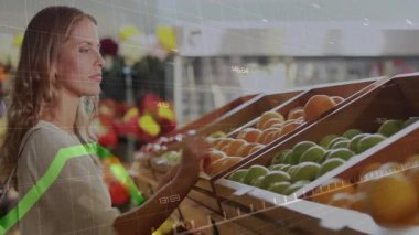 Bakkal koridoruna gelen kadın meyve tarıyor portakal seçiyor elmaları tarıyor tazelik kokusu alıyor. Taze ürün, market alışverişi, sağlıklı yaşam tarzı, organik, doğal, enerjik, tüketici