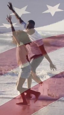 Amerika Birleşik Devletleri bayrağının Afrika kökenli Amerikalı baba ve kızının kumsalda olması üzerine canlandırılması. Amerikan tarihi, vatanseverlik ve bağımsızlık kavramı dijital olarak oluşturulmuş video.