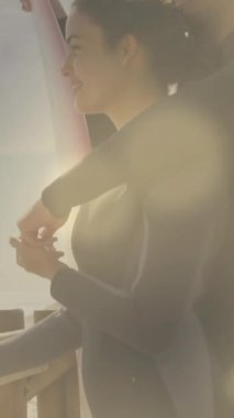 Sörf tahtası olan beyaz bir çiftin üzerinde benekler. Boş zaman, tatiller ve dijital arayüz kavramı dijital olarak oluşturulmuş video.