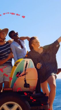 Animation of hearts forming heart shape over multiracial friends taking selfie against sea and sky. Digital composite, love, togetherness, holiday, enjoyment, weekend, technology and nature.