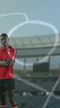 Bir Afro-Amerikan erkek rugby oyuncusu çapraz kolları ile ayakta animasyon ve arka planda 4k ön planda ve spor stadyumunda elle çizilmiş oyun planı ile kameraya bakıyor