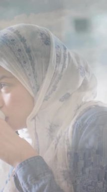 Başörtülü çay içen bir kadının şehir manzarası animasyonu. Yaşam tarzı, ev hayatı ve mutluluk konsepti dijital olarak oluşturulmuş video.