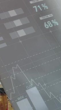 4k ön planda grafik ve istatistiklerle birlikte atölyesindeki planlara bakan beyaz bir adamın dijital bileşimi