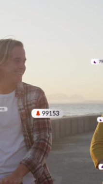 Gülümseyen beyaz bir çiftin deniz kenarında scooter sürmesi üzerine afişlerde sosyal medya simgelerinin canlandırılması. Sosyal medya, dijital arayüz ve bağlantılar konsepti dijital olarak oluşturulmuş video.