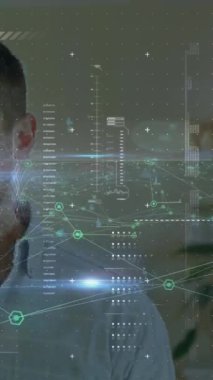 Animation of network of connections and network of icons over caucasian man talking on smartphone. Global networking and business technology concept