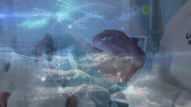 Kıdemli hekim maskesini ayarlıyor grafikleri aktifleştiriyor ve tableti alıp tıbbi bulut verilerini analiz ediyor. Sağlık, teletıp, dijital sağlık, hastane, asker, tıbbi teknoloji, yaşlı bakımı