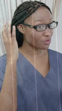 Kıdemli hasta için işitme cihazına uyan Afrika kökenli Amerikalı kadın doktor üzerindeki DNA ipliğinin animasyonu. Veri, dijital arayüz, bağlantı, hastane ve sağlık hizmetleri, dijital olarak oluşturulmuş video.