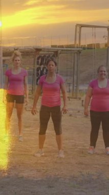 Engelli parkurda atlayan çeşitli kadınlar üzerinde günbatımının canlandırması. Küresel spor, sağlık, fitness ve dijital arayüz kavramı dijital olarak oluşturulmuş video.