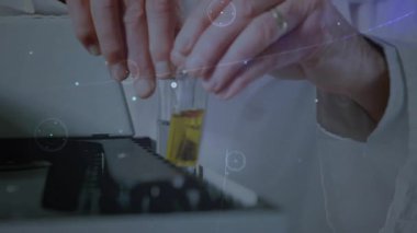 Kıdemli bilim adamı deney tüpü rafına ulaşıyor. Bilim laboratuarında dijital kaplamanın altındaki sarı şişeyi karşılaştırıyor. Araştırma, yenilik, teknoloji, kesinlik, deney, analiz, biyomoleküler