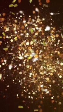 Altın konfetilerin arka planda parlayan altın noktaların üzerine düşmesi. Renk ve hareket kavramı dijital olarak oluşturulmuş video.