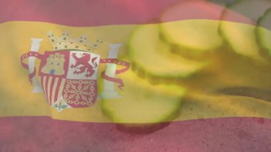 Dalgalanan İspanyol bayrağı, patates dilimlerini başlatarak gri tezgahta sarı şeritlerin arkasına sürükleniyor. Vatanseverlik, ulusal, kutlama, aşçılık, soyut, canlı, modern