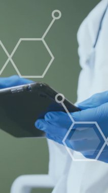 Hastanede tablet kullanarak yüz maskesi takmış doktorların üzerinde hareket eden bilimsel diyagramların animasyonu. Dijital olarak üretilen video konsepti boyunca tıbbi teknoloji ve sağlık hizmetleri.