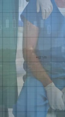 Animation of financial data over caucasian female and male surgeons. Health, medicine, finance and economy concept digitally generated video.