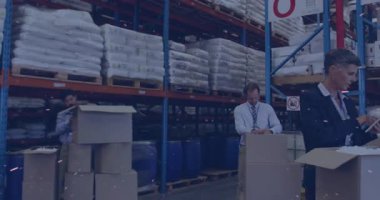 Depo çalışanları siparişleri topluyor, adam öne çıkıp bant kesiciyi alıyor ve dikişleri kapatıyor. Sanayi, lojistik, dağıtım, üretkenlik, takım çalışması, verimlilik, operasyonel