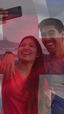 Mutlu çift selfie çekerken İngiliz bayrağının animasyonu. Amerikan vatanseverliği, bağımsızlık ve çeşitlilik kavramı dijital olarak oluşturulmuş video.