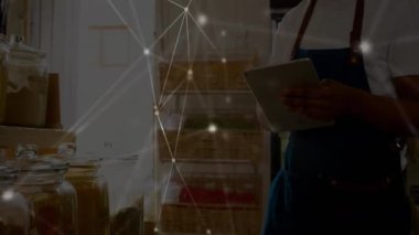 Solan mağaza tezgahtarının tablet tıklaması ve envanter için kavanozları denetlemesiyle dijital ağ örtüşüyor. Teknoloji, ticaret, minimalizm, yenilik, perakende, kesinlik, organizasyon