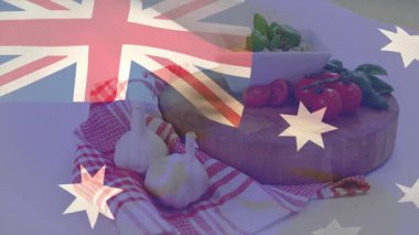 Avustralya bayrağı, havlunun üzerinde sarımsak sallayarak domates fesleğeniyle dinamik hareketler ekliyor. Gurme, aşçı, doğal, kırsal, canlı, tazelik, vatanseverlik