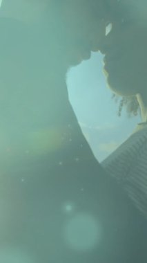 Sahildeki Afrikalı Amerikalı çiftin üzerindeki ışık noktalarının animasyonu. Tatiller ve dijital arayüz kavramı dijital olarak oluşturulmuş video.