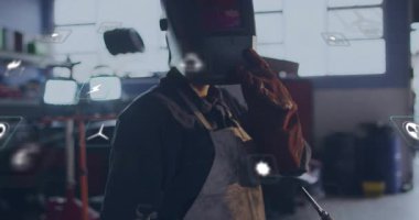 Fabrika verileri için dijital simgeler etrafında dönerken kaynakçı el ile kaskı kaldırıyor. Sanayi, zanaat, teknoloji, yenilik, robotik, güvenlik, sürdürülebilirlik