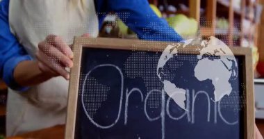 Elle karatahta bakkal tedarikçisi organik işaretleri ayarlarken dünya da ürünleri gösteriyor. Tazelik, tarım, beslenme, perakende, doğal, sağlık, sürdürülebilirlik