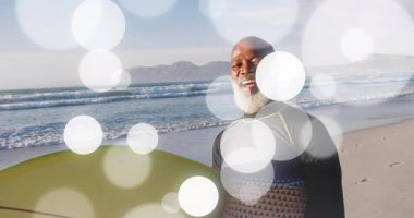 Sörf tahtası, gündoğumu kumsalında tutunmak için dik bir şekilde kayıyor. Bokeh daireler çiziyor. Sahil, gün doğumu, açık hava, rahatlık, huzur, macera, doğal