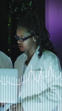 Sunucu odasında dizüstü bilgisayarda çalışan Afro-Amerikan erkek ve kadın grafiklerinin animasyonu. ağ, programlama, bilgisayarlar ve teknoloji konsepti dijital olarak oluşturulmuş video.