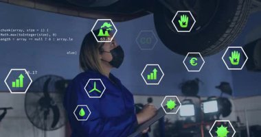 Tamirci garaja giriyor, ekolojik kontrolü güncelleyen altıgen ölçümleri ile şasiyi inceliyor. Teknisyen, bakım, dijital, yenilik, sürdürülebilirlik, sanayi, analiz