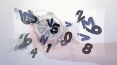 Elin sağdan girmesi twinbell saatini tutuyor ve rakamlar yüzün etrafında dönerek zamanı temsil ediyor. Zaman, hareket, veri, dijital, soyut, teknoloji, yenilik