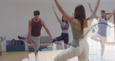 Yoga stüdyo grubunda hoca işaret veriyor. Ağaç duruşu yapıyorlar. Tablolar nefes gösteriyor. Sağlık, zindelik, farkındalık, denge, meditasyon, canlılık, sağlık