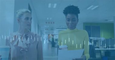 Meslektaşlar iş koridorunda yürüyorlar, rapora işaret ediyorlar, ilerlemeyi gösteren verileri aktifleştiriyorlar. Profesyonel, takım çalışması, modern, işbirliği, canlı, iletişim, kurumsal