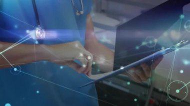 Ağ grafiği canlandırırken sağlık çalışanı çizelgeyi gösteriyor sonra sayfayı tarıyor ve gülümsüyor. Sağlık, dijital, teknoloji, profesyonellik, analiz, veri, yenilik