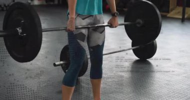 Spor salonunda halteri tutan, ağırlık kaldıran ve kondisyon için koşan bir kadın. Güç, zindelik, atletizm, güç, kararlılık, egzersiz, eğitim