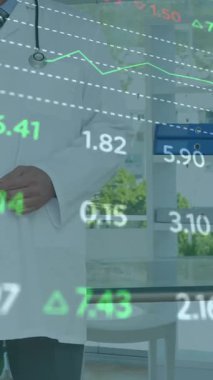Animation of stock market data processing over caucasian male doctor smiling at hospital. Global economy and medical healthcare technology concept
