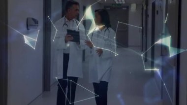 Kadın ve erkek doktorlar koridorda yürürken tablet kaydırarak sanal dünyayı şekillendiren bir ağ oluşturuyorlar. Tıbbi, teknoloji, yenilik, işbirliği, fütüristik, araştırma, sağlık hizmetleri