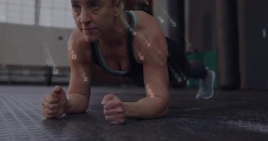 Spor salonunda ön kol kalası tutan bir kadın. Vücut geliştirme analitiği için çekirdeğin etrafındaki ikili kaplamaları etkinleştiriyor. Fitness, digital, analytics, strength, determination, technology, industrial