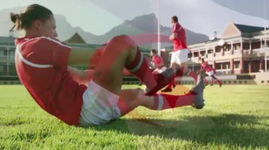 Oturan oyuncuya odaklanan kamera ve çimenler üzerinde futbol antrenmanı için krampon bağlama işlemini başlatıyor. Atletizm, takım çalışması, açık hava, kırsal alan, fitness, motivasyon, spor