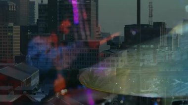 Davulcu yükseltme çubuğu alacakaranlıkta çatıda zile basıyor renkli fişeklerle müzik vuruşları yapıyor. Şehir, ufuk çizgisi, konser, gece hayatı, ışıklandırma, atmosfer, performans