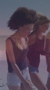 Animation of lens flares over diverse young friends walking at beach during sunny day. Digital composite, cheerful, togetherness, nature, illuminated, enjoyment and vacations concept.