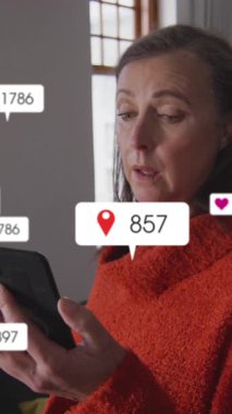 Sosyal medya simgelerinin evde akıllı telefon kullanırken hapşıran Kafkasyalı yaşlı kadın üzerine animasyonu. Sosyal medya ağ teknolojisi kavramı