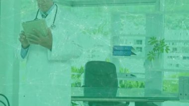 Orta yaşlı bir doktor köşe ofise giriyor ve hasta verilerini teşhis için tablete kaydırıyor. Profesyonel, sağlık, modern, teknoloji, danışma, klinik, şirket