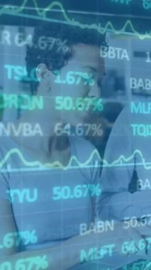 Animation of financial graphs and data over diverse female coworkers in office. Business, finance, economy, data processing and technology concept digitally generated video.