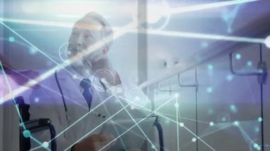 Tekerlekli sandalye tıkırtısı tabletindeki doktor, parlayan ağ düğümlerine erişiyor ve koridordaki verileri doğruluyor. Tıbbi, sağlık, dijital, teknoloji, profesyonellik, yenilik, fütürizm