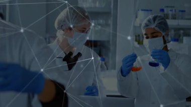 Laboratuvar teknisyenleri sıvıları mikroskopla inceleyerek verileri atım kaplamalarıyla karşılaştırıyor. Bilim insanları, yenilik, araştırma, dijital, analiz, işbirliği, teknoloji